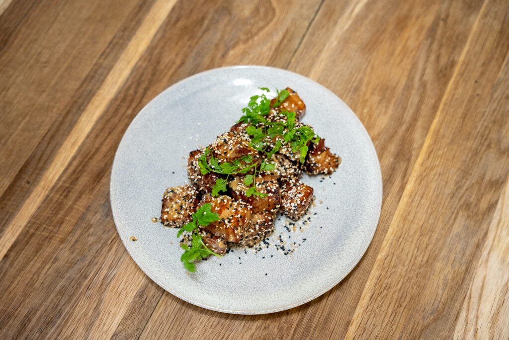 Ret med sprød topping og friske urter på lys tallerken